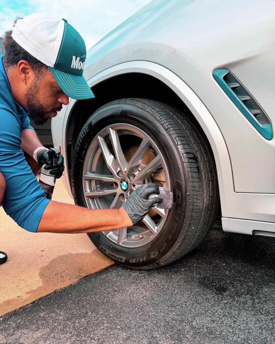 Max Crew detailer applying tire shine to a freshly cleaned wheel